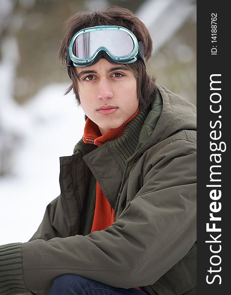 Teenage Boy Wearing Winter Clothes In Snowy Landscape