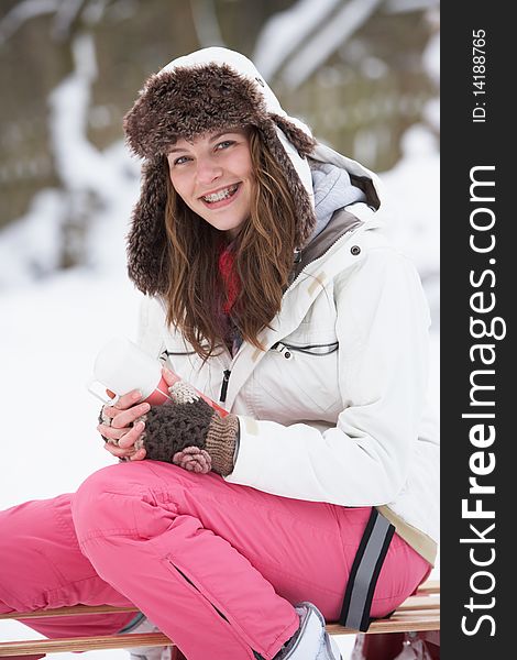 Teenage Girl Sitting On Sledge With Flask And Hot Drink. Teenage Girl Sitting On Sledge With Flask And Hot Drink