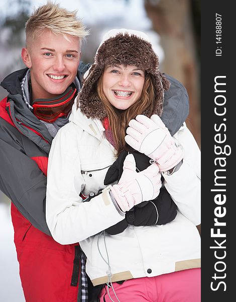 Romantic Teenage Couple In Snow Wearing Winter Clothing