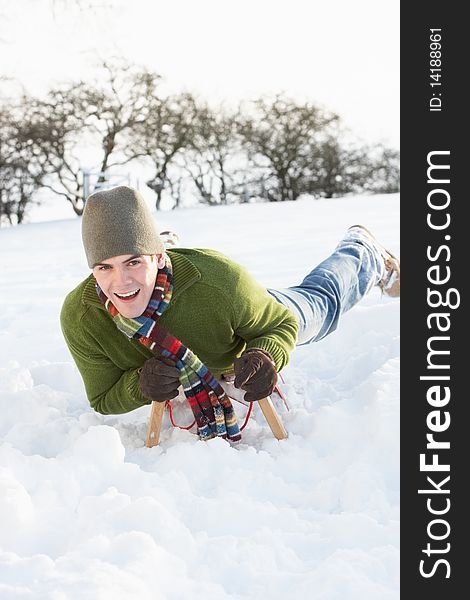 Man Riding On Sledge In Snowy Landscape