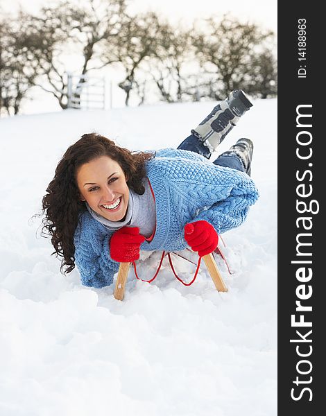 Woman Riding On Sledge In Snowy Landscape