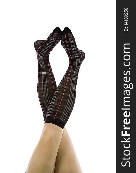 Womans legs up in the air with black socks that have pink stripes. Womans legs up in the air with black socks that have pink stripes.