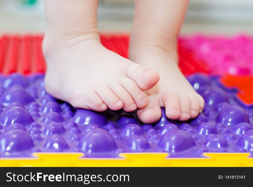 Little children`s feet on an orthopedic mat. Little children`s feet on an orthopedic mat