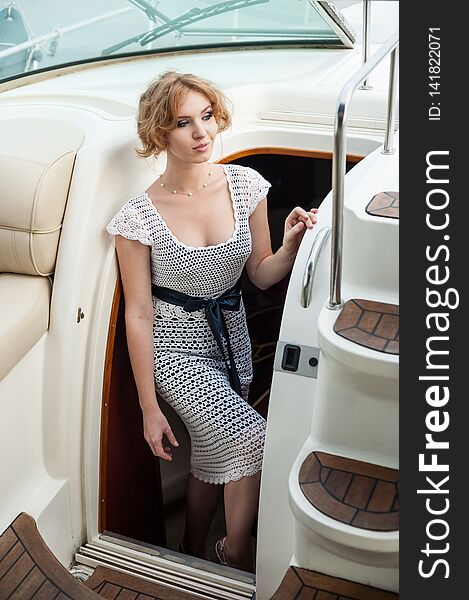 Portrait of a girl in a white knitted dress on the yacht