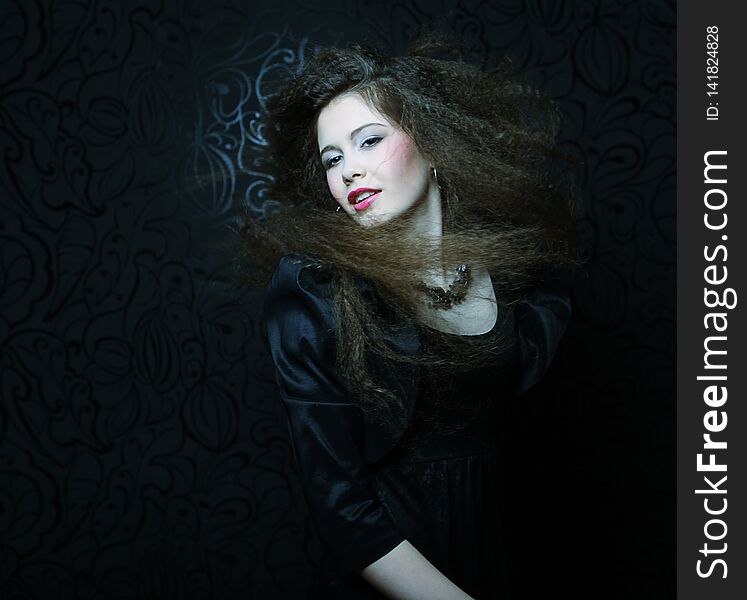 High fashion model in black dress, with creative hairstyling on black background