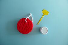 Red Bath Sponge, White Cream Box And Empty Yellow Label On A Light Blue Background Royalty Free Stock Photos