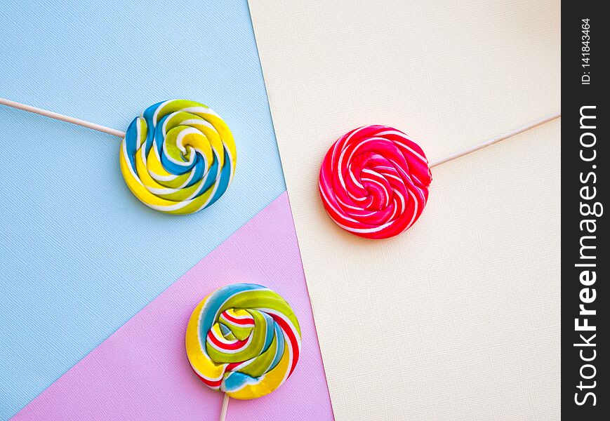 Different tasty colorful candies on pastel color background.