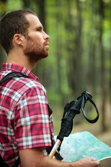 Determined Young Man Hiking Through Lush Green Forest, Holding A Map And Navigating Royalty Free Stock Image Determined Young Man Hiking Through Lush Green Forest, Holding A Map And Navigating Royalty Free Stock Image