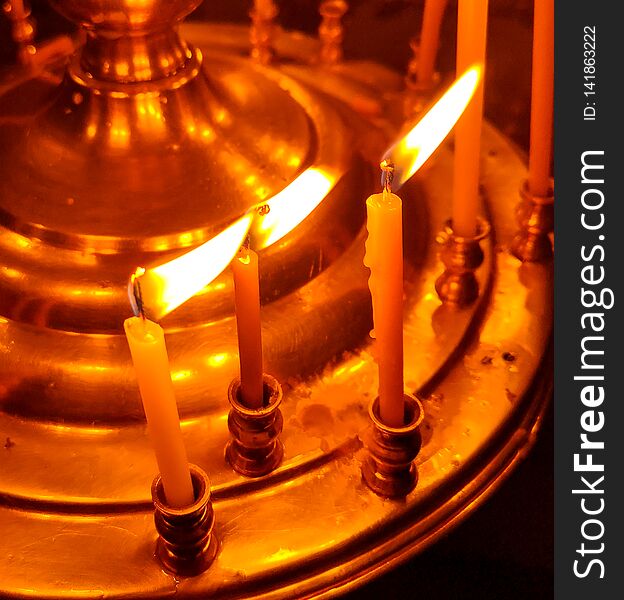 Candles are burning in the church as a background . Candles are burning in the church as a background .