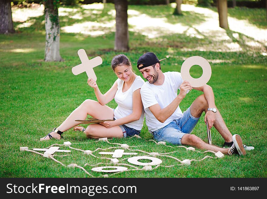 Laughing Boy And Girl Playing Tic-tac-toe In The Park.