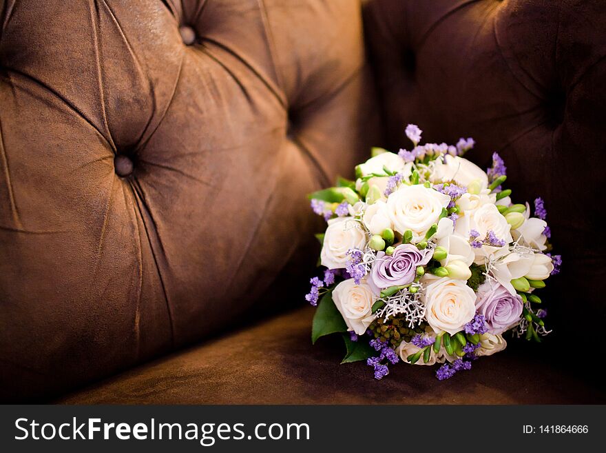 Bouquet in brown sofa. Purple and creamy roses in still life concept. Bouquet in brown sofa. Purple and creamy roses in still life concept