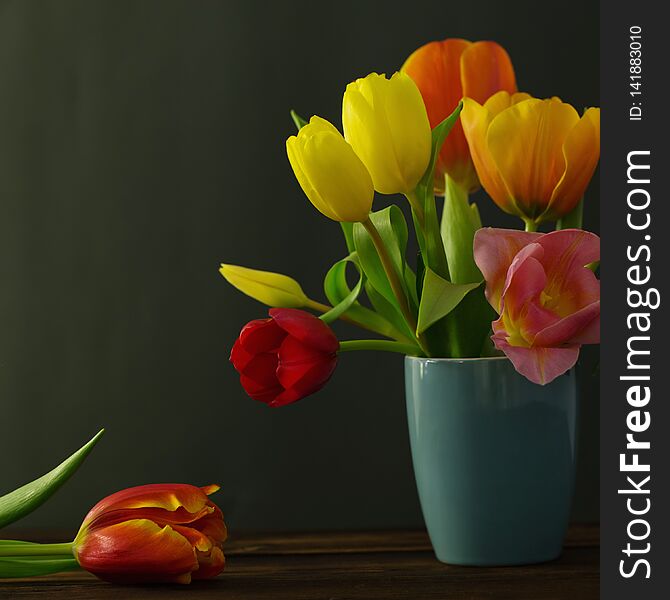 Beautiful tulips in vase on green background