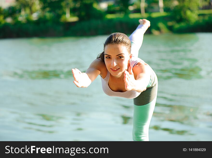 Beautiful Young Woman Meditating In Yoga Pose At A Mountain Stream