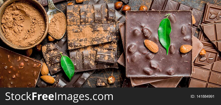 Chocolate pieces with leaves. On a wooden background