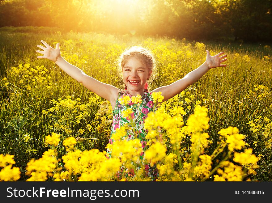 Happy cheerful little girl among yellow wildflowers. Happy cheerful little girl among yellow wildflowers