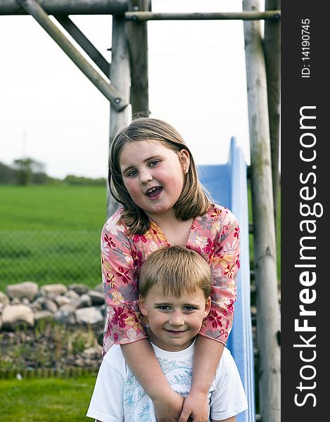 Portrait of two young sibs on a slide. Portrait of two young sibs on a slide