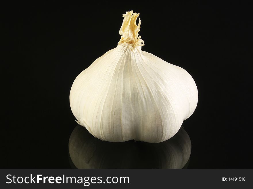 One garlic on a black background