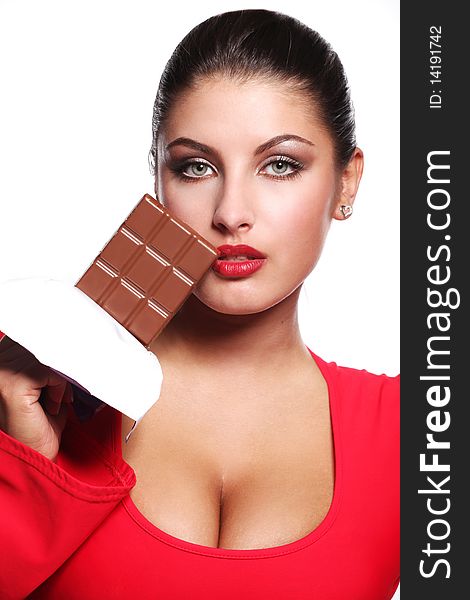 Young beautiful woman in red dress eating chocolate. Young beautiful woman in red dress eating chocolate
