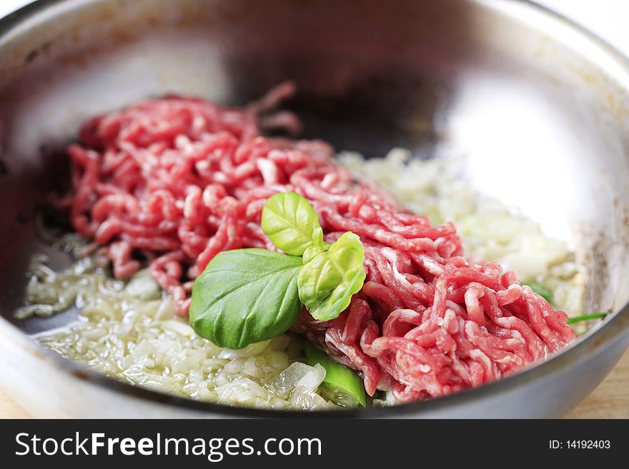 Raw minced beef and chopped onion in a pan