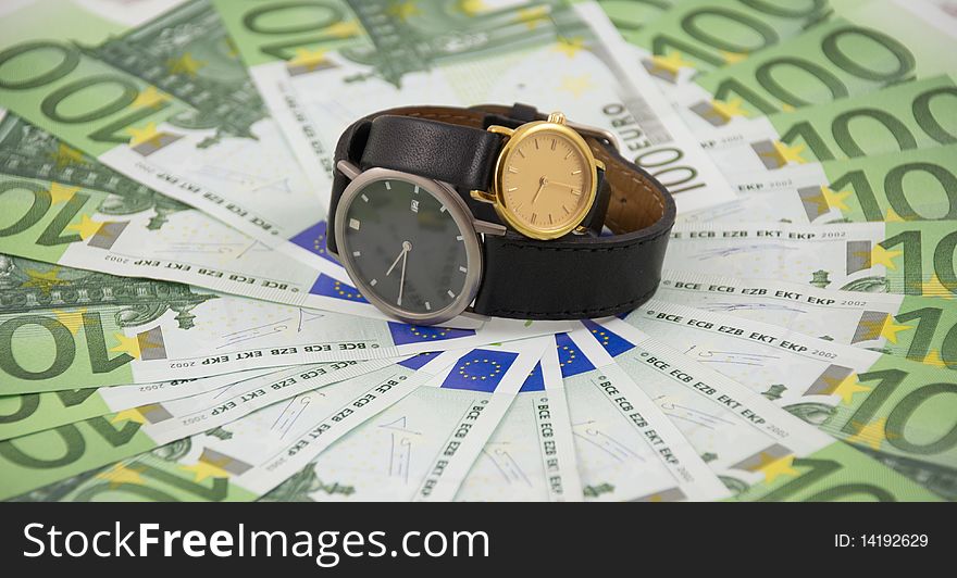 Time is money concept photo: two watches on one hundred euro banknotes background