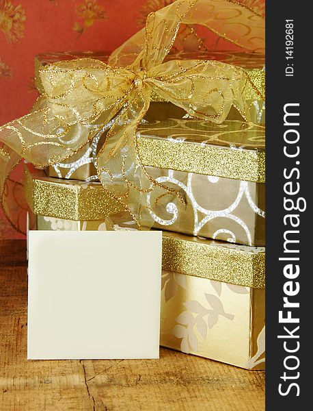 Gift boxes stacked with gold ribbon and gift card blank for your text. Gift boxes stacked with gold ribbon and gift card blank for your text.