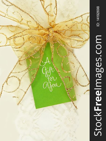 Gold ribbon and gift tag on white box. Gold ribbon and gift tag on white box.