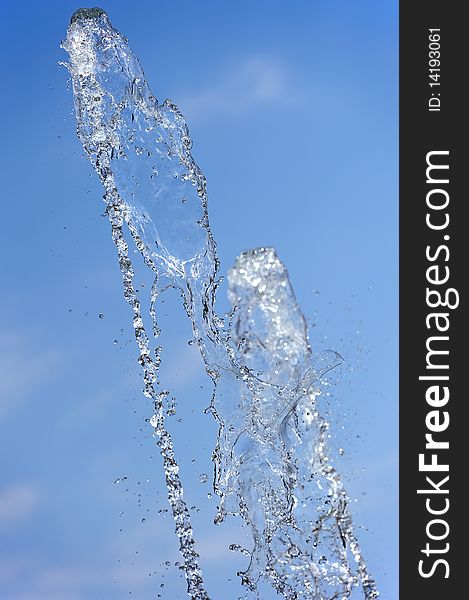 Water shooting out of a fountain with a bright blue background. Water shooting out of a fountain with a bright blue background