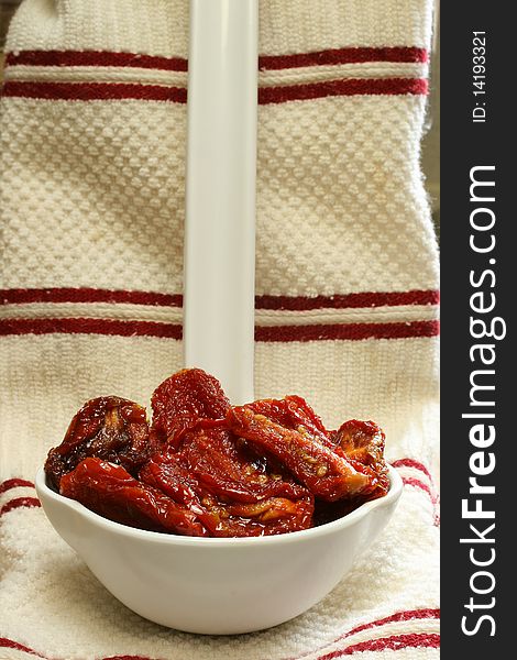 Sun Dried Tomatoes in Olive Oil sitting in large white kitchen spoon