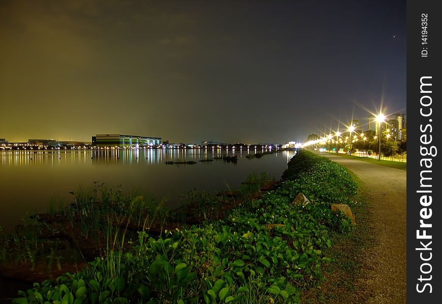 Pandan Reservoir with a lit walkway and green plants by night. Pandan Reservoir with a lit walkway and green plants by night