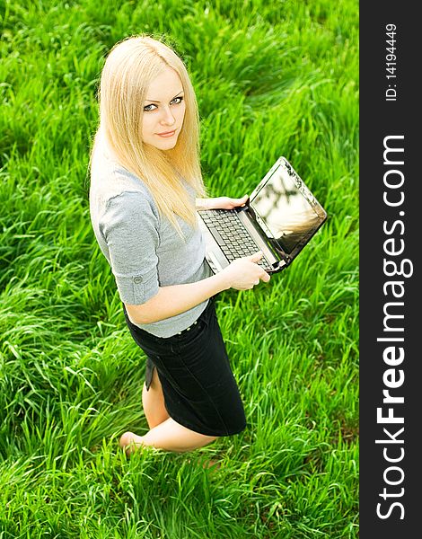 Series. The beautiful business woman with the laptop has a rest in the field