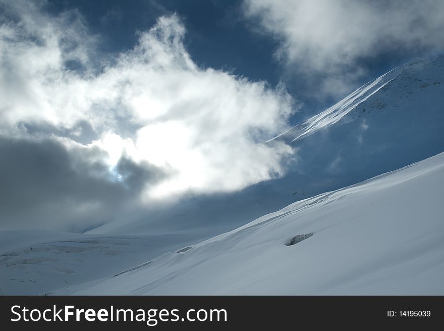 Sun shining through the cloud covering snowy slope. Sun shining through the cloud covering snowy slope.