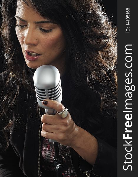 Portrait of young beautiful brunette woman singing with retro microphone. Portrait of young beautiful brunette woman singing with retro microphone