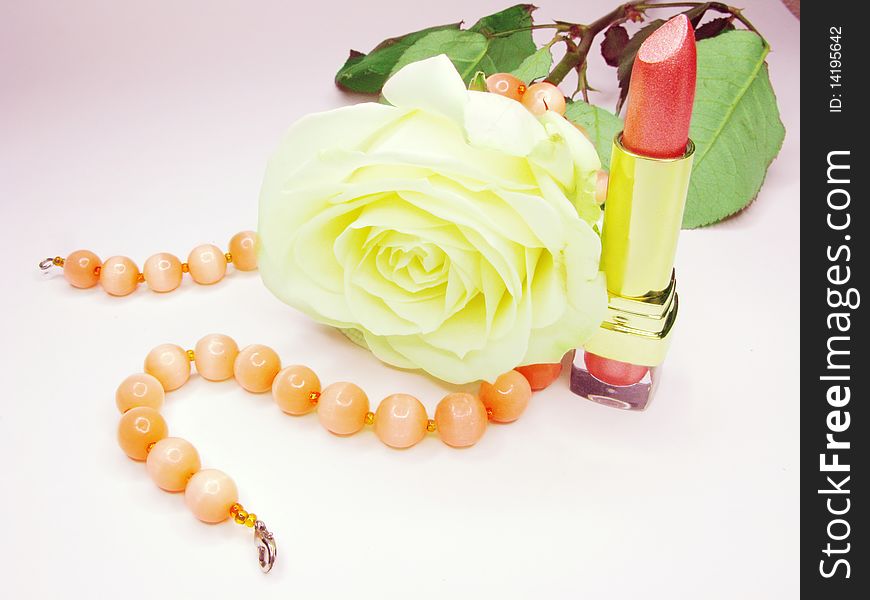 Pink lipstick in gold box with white rose on background. Pink lipstick in gold box with white rose on background