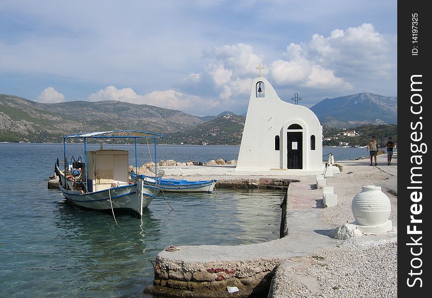 Greek Harbor on a salt lake with typical boat and church