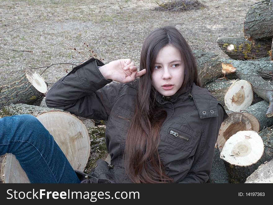 Young beautiful teenage girl lying on logs. Young beautiful teenage girl lying on logs