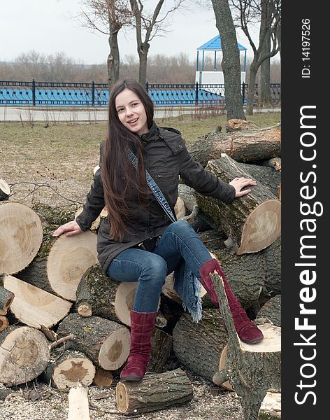 Young beautiful girl sitting on logs. Young beautiful girl sitting on logs
