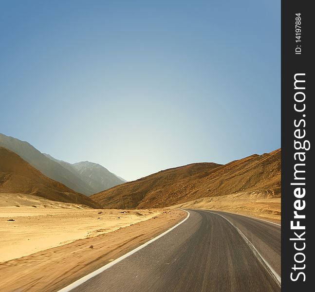 Image of a road in an Egyptian desert on a sky background. Panoramic view. Image of a road in an Egyptian desert on a sky background. Panoramic view.