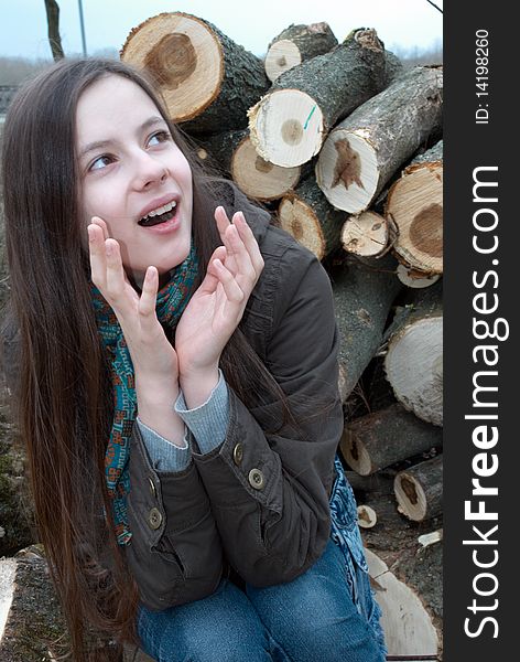 Close-up of young teenage girl sitting on logs. Close-up of young teenage girl sitting on logs