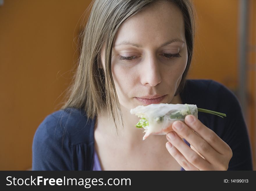 Woman eating a spring roll. Woman eating a spring roll