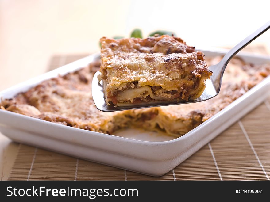 Lasagna in white casserole with basil