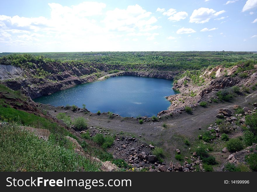 Landscape with blue deep lake in large granite open pit. Landscape with blue deep lake in large granite open pit