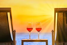 Wine Glasses Of Red Wine On The Red Background Of The Sea Royalty Free Stock Image