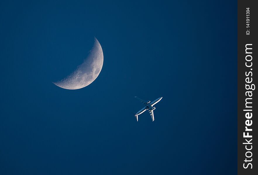 Airliner and Crescent Moon in a Dark Blue Sky