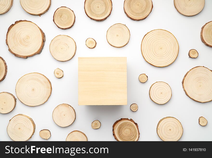Pine tree cross-sections with annual rings and wooden square on white background. Lumber piece close-up, top view.