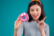 Asian Beauty Girl Holding Pink Donut. Retro Joyful Woman With Sweets, Dessert Standing Over Blue Background Stock Image