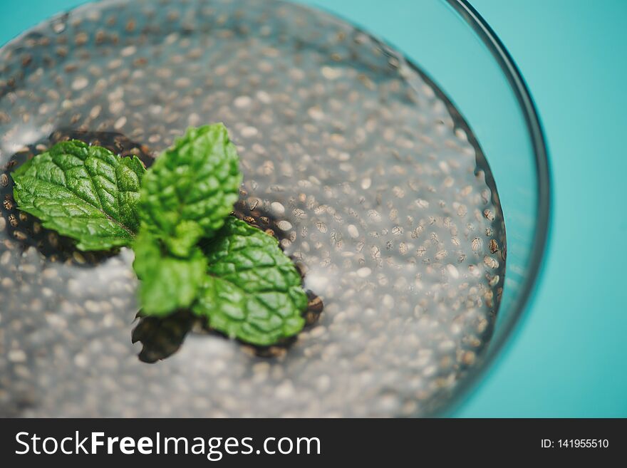 Glass of water with cup of healthy chia seeds and spoon. Text space