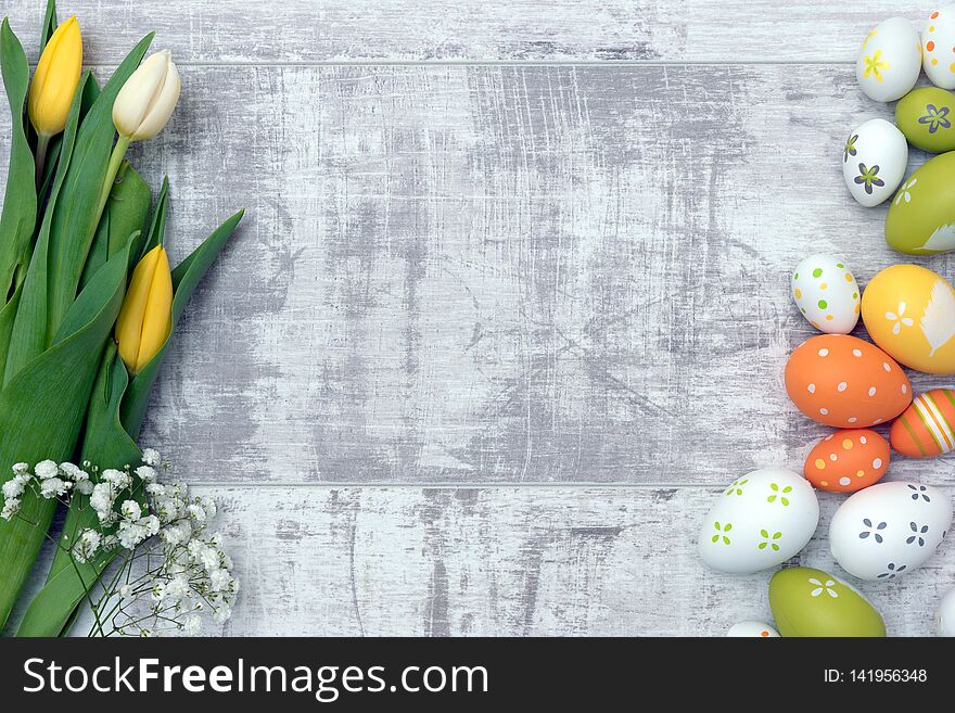 Easter eggs and spring flowers background. Top view with copy space. Easter eggs and spring flowers background. Top view with copy space