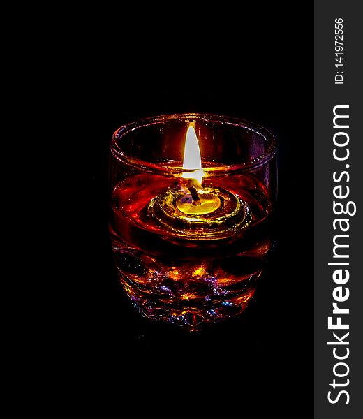 Home interior decoration made of burning fuse in glass filled with water and oil, photographed in a dark environment