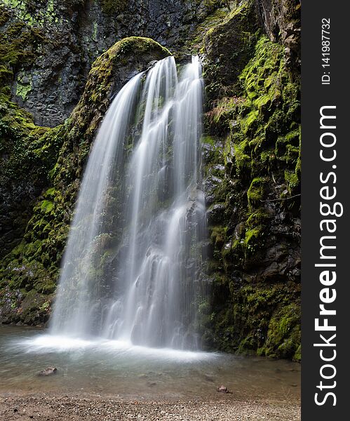 Waterfall surrounded by green mossy rocks in the forest. Waterfall surrounded by green mossy rocks in the forest.