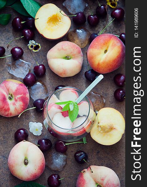 Cocktail with organic fresh peaches and cherries